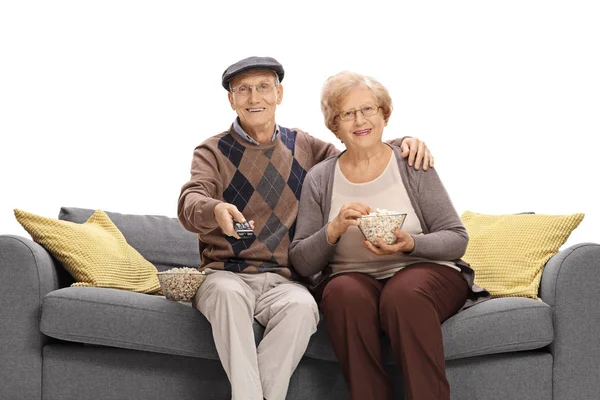 Casal de idosos assistindo televisão e comendo pipocas — Fotografia de Stock