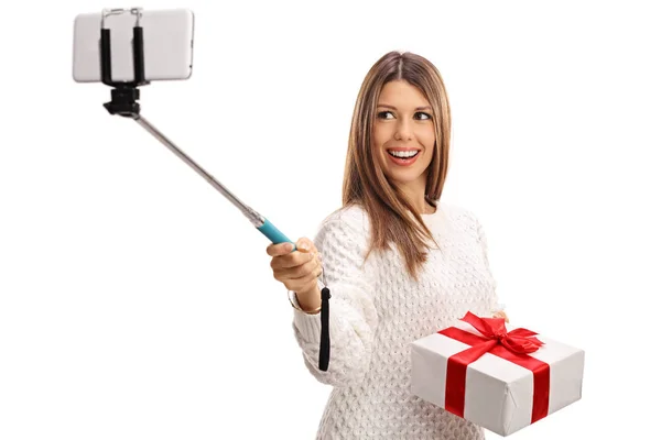 Femme tenant présent et prenant selfie avec un bâton — Photo