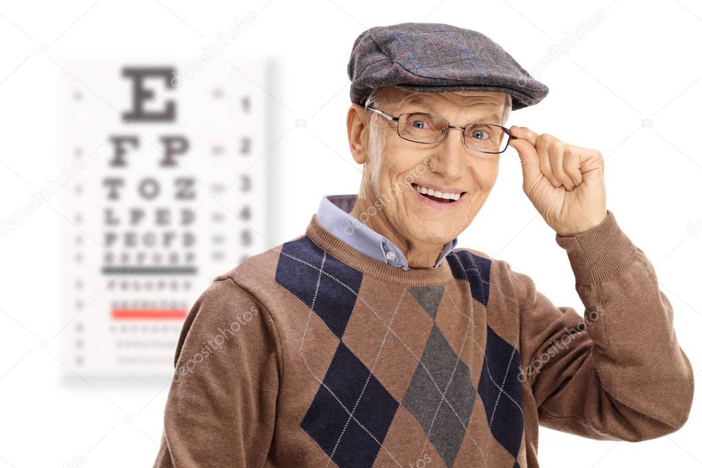 Elderly man smiling in front of an eye chart