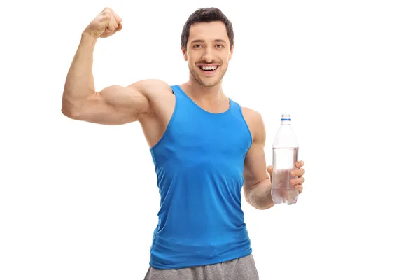 Man hålla flaska vatten och muskelbygge hans biceps — Stockfoto