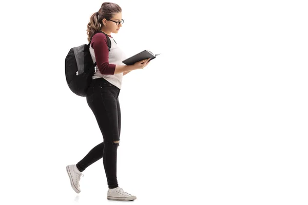 Estudante com mochila caminhando e lendo livro — Fotografia de Stock