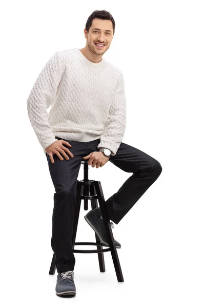 Bir sandalye gülümseyerek oturan genç adam — Stok fotoğraf