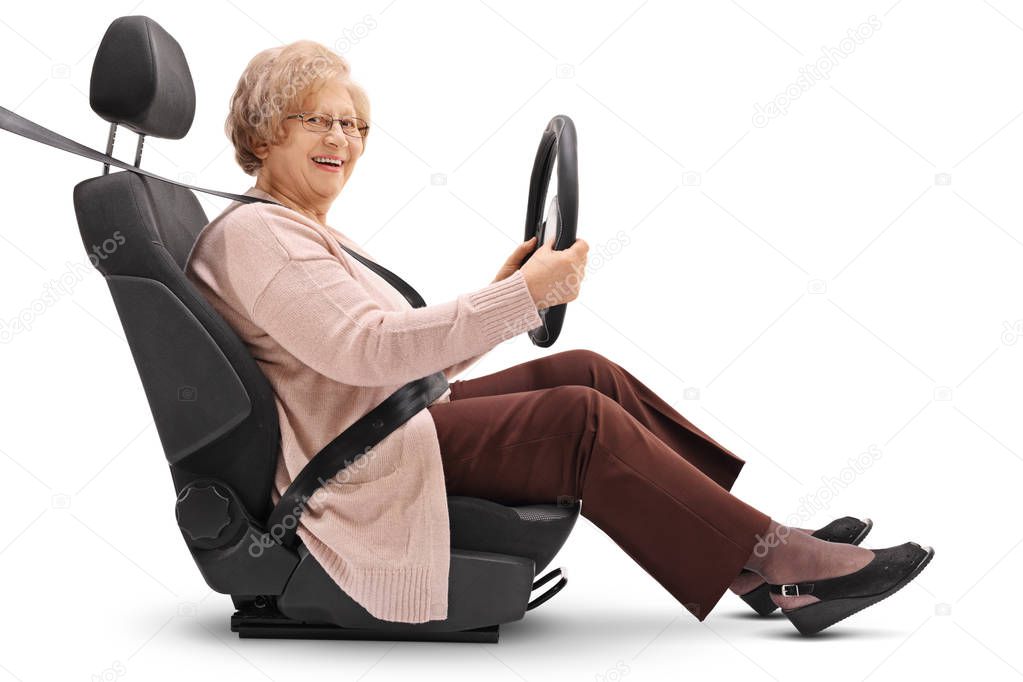 Elderly woman seated in car seat holding steering wheel