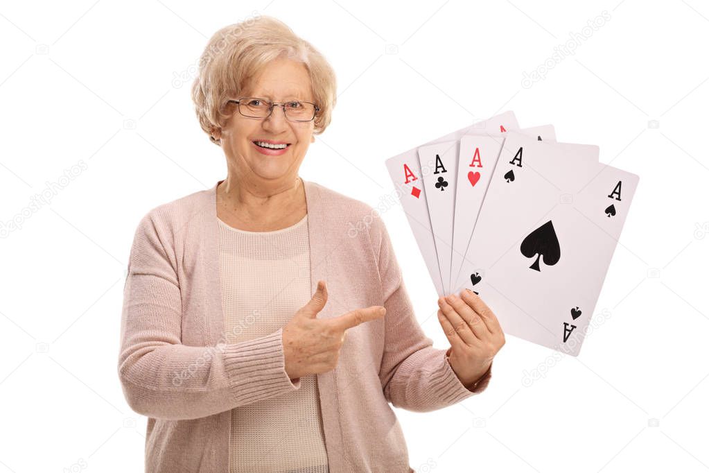 Mature woman holding four aces and pointing