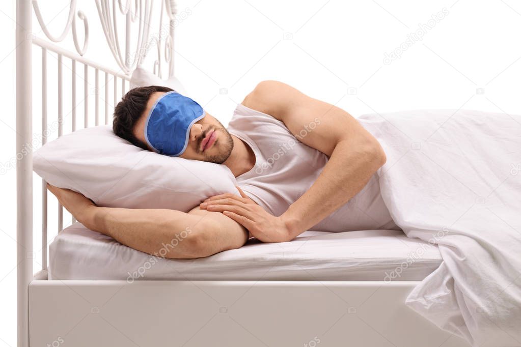 man sleeping in bed with an eye mask