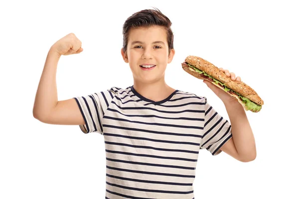Chico flexionando sus bíceps y sosteniendo un sándwich — Foto de Stock