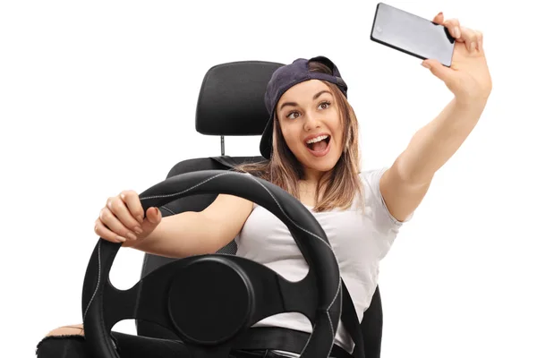 Chica alegre sentado en el asiento del coche y tomar selfie —  Fotos de Stock