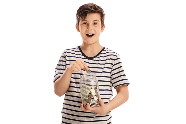 Chico alegre poniendo una moneda en un frasco — Foto de Stock