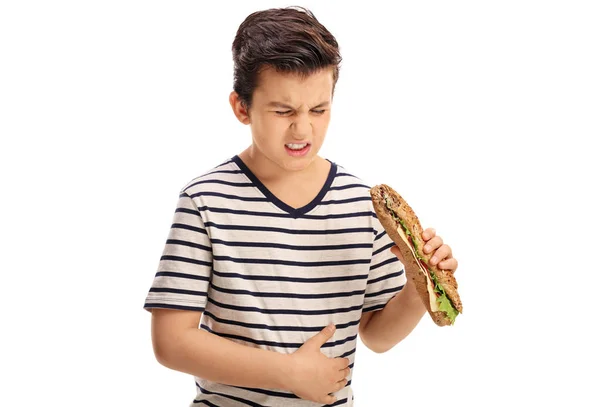 Junge isst ein Sandwich und hat Bauchschmerzen — Stockfoto