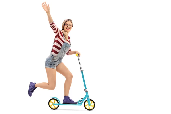 Female hipster riding a scooter and waving — Stock Photo, Image