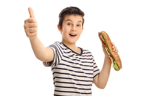 Chico sosteniendo un sándwich y dando un pulgar hacia arriba — Foto de Stock