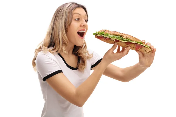 Νεαρή γυναίκα τρώει ένα σάντουιτς — Φωτογραφία Αρχείου