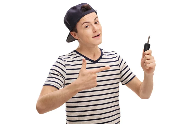 Teenage boy holding a car key and pointing — Stock Photo, Image