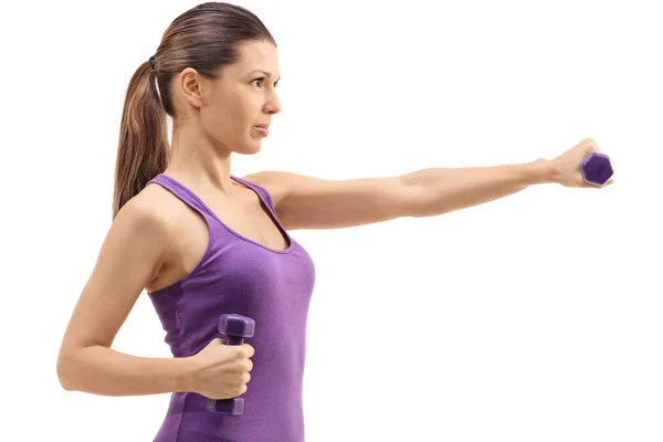 Profile shot of a woman exercising with dumbbells — Stock Photo, Image