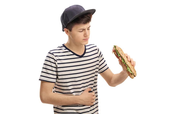 Dospívající s sendvič a zažívá bolest žaludku — Stock fotografie
