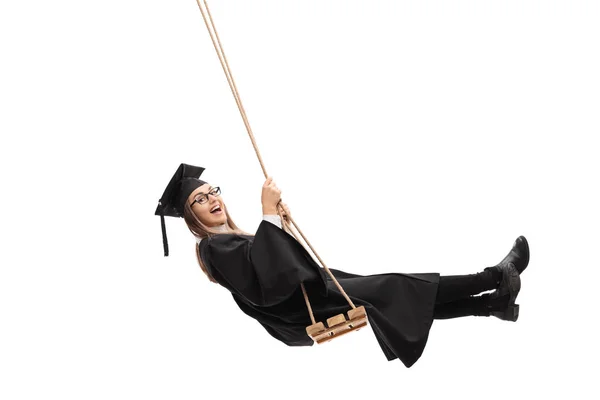Alegre estudiante graduado balanceándose en un columpio —  Fotos de Stock