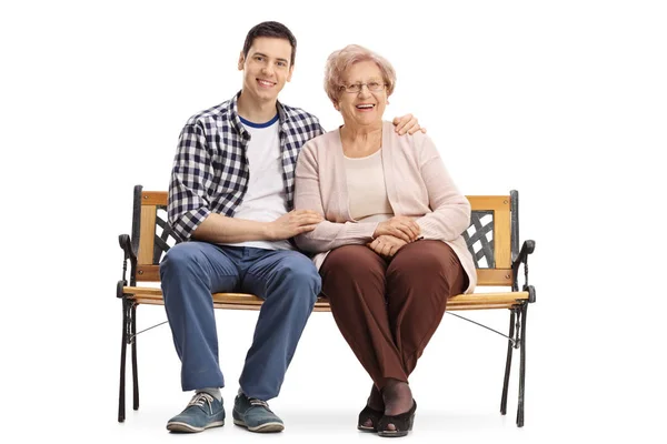 Νεαρός άνδρας και μια ηλικιωμένη γυναίκα που κάθεται σε ένα παγκάκι — Φωτογραφία Αρχείου