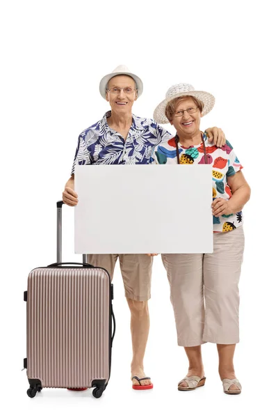 Mature tourists with a suitcase holding a blank signboard — Stock Photo, Image