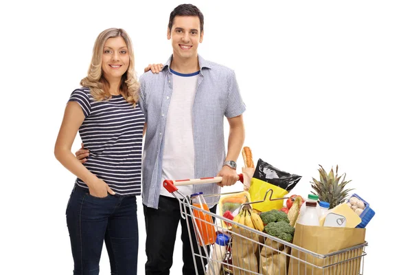 Couple with a shopping cart full of groceries — Stock Photo, Image