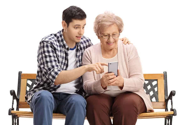 Mężczyzna prezentujący starszą kobietę do korzystania z telefonu komórkowego — Zdjęcie stockowe
