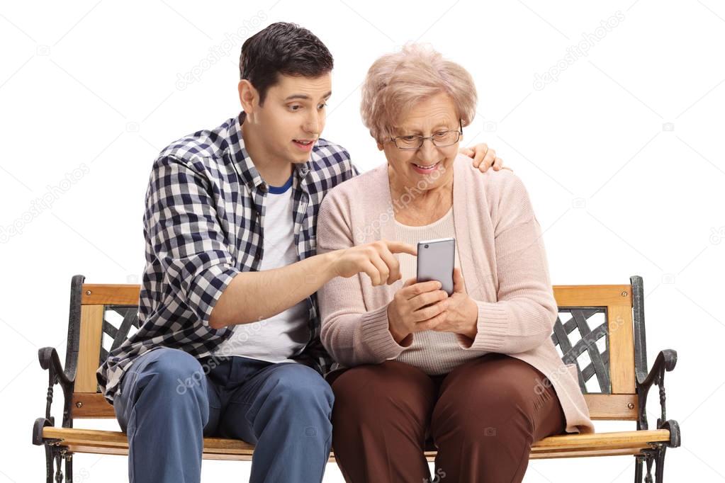 man showing elderly woman how to use mobile phone