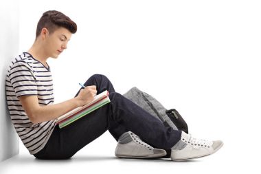 Teen öğrenci bir defterde yazılı