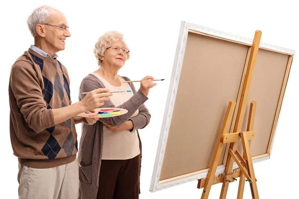 Homem idoso e mulher pintando em uma tela com pincéis — Fotografia de Stock