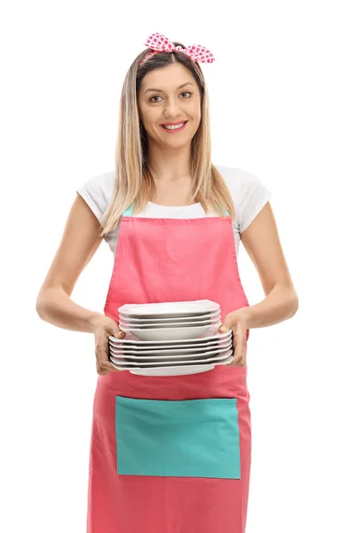 Happy housewife holding a stack of plates — Stock Photo, Image