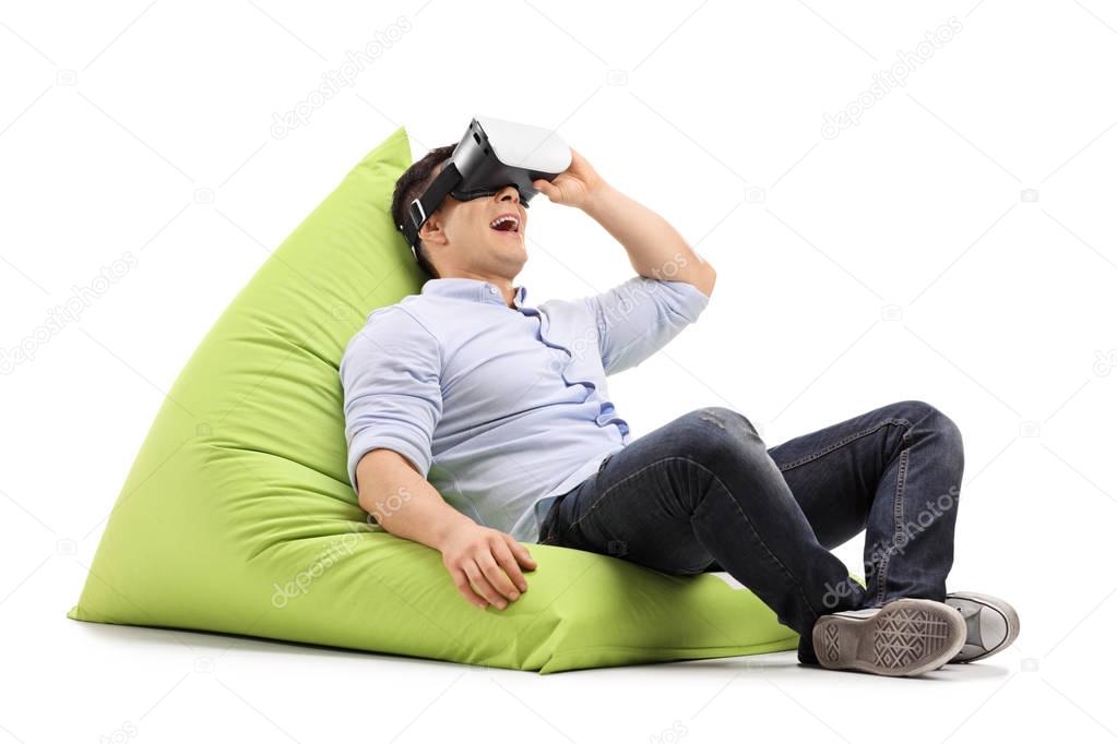 Joyful guy using virtual reality headset 