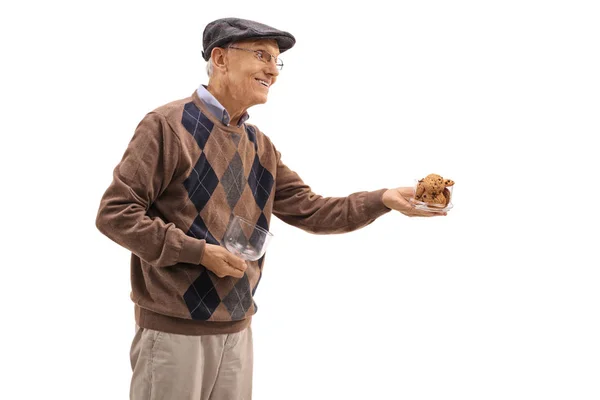 Mature man offering cookies — Stock Photo, Image