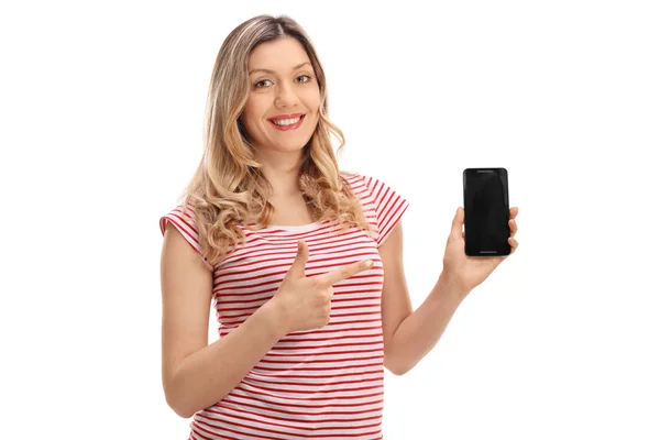 Счастливая женщина держит телефон и указывает — стоковое фото