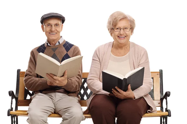 Uomo e donna anziani con libri seduti su una panchina — Foto Stock