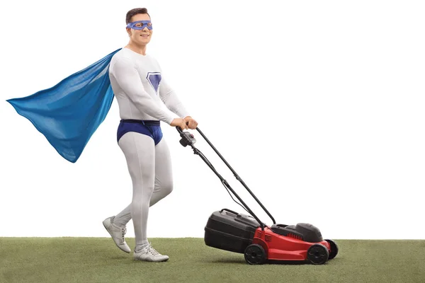 Süper kahraman ile bir çim biçme makinesi biçme ve kameraya bakıyor — Stok fotoğraf