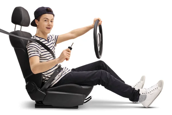 Teenager in car seat holding steering wheel and car key — Stock Photo, Image