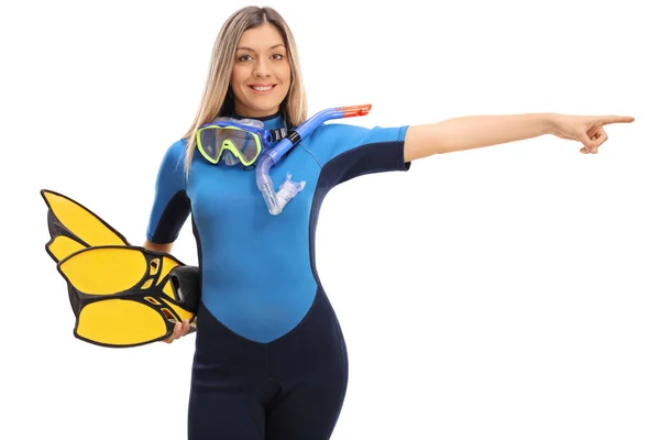Woman in a swimsuit and snorkeling equipment pointing right — Stock Photo, Image