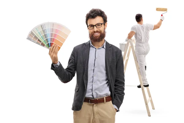 Человек держит цветные образцы с живописной живописью — стоковое фото