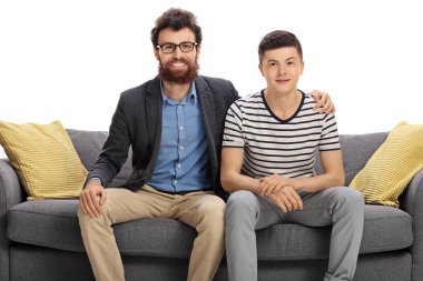 Man and a teenage boy sitting on a sofa clipart