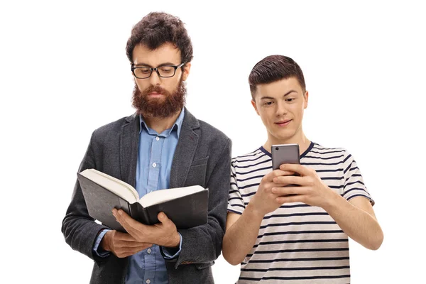 Mann liest Buch mit Teenager-Junge, der auf Handy schaut — Stockfoto