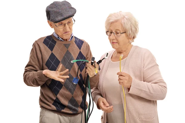 Seniors looking at different types of electronic cables — Stock Photo, Image