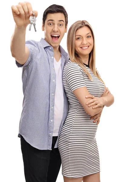 Freudiges junges Paar mit einem Schlüsselpaar — Stockfoto