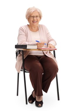 Bir okul sandalyede oturuyor neşeli olgun kadın