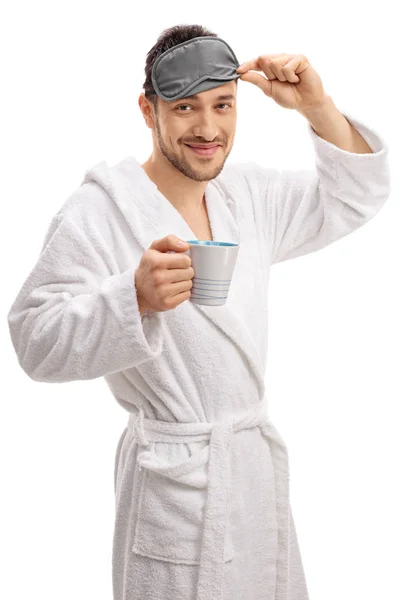 Typ mit Bademantel und Schlafmaske, der eine Tasse hält — Stockfoto