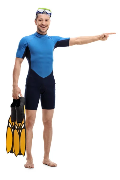 Seorang pria dalam baju selam dengan peralatan snorkeling menunjuk kanan — Stok Foto