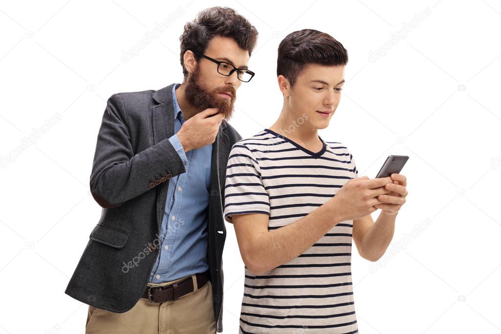 Concerned father looking at the phone of his teenage son