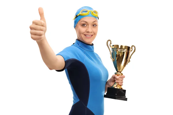 Schwimmerin mit Goldtrophäe und Daumen-hoch-Geste — Stockfoto