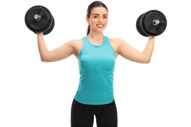 Dambıllarla egzersiz yapan genç bir kadın.