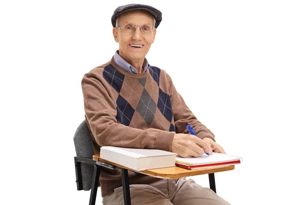 Estudiante de edad avanzada en una silla de la escuela tomando notas — Foto de Stock