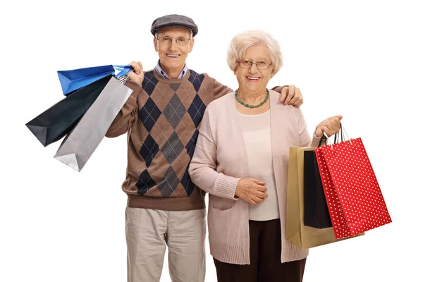 Happy elderly couple with shopping bags — Stock Photo, Image