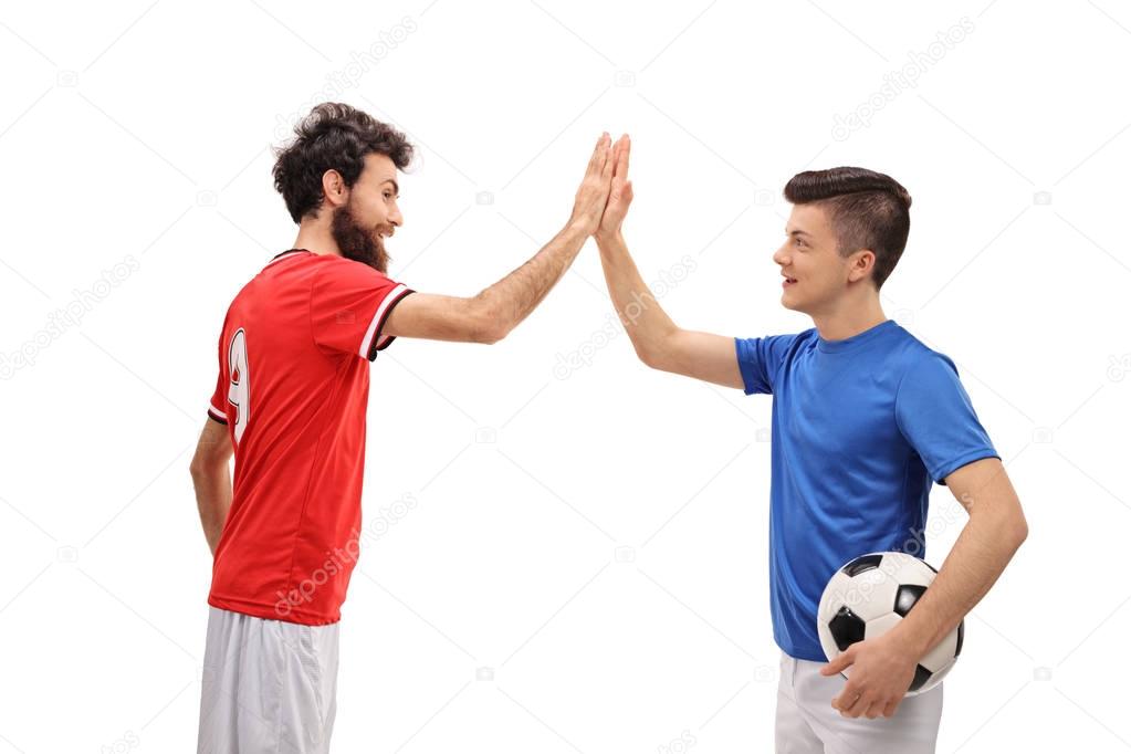 Father and son dressed in sport jerseys high fiving