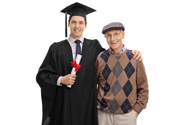 Выпускник и его дедушка смотрят в камеру — стоковое фото